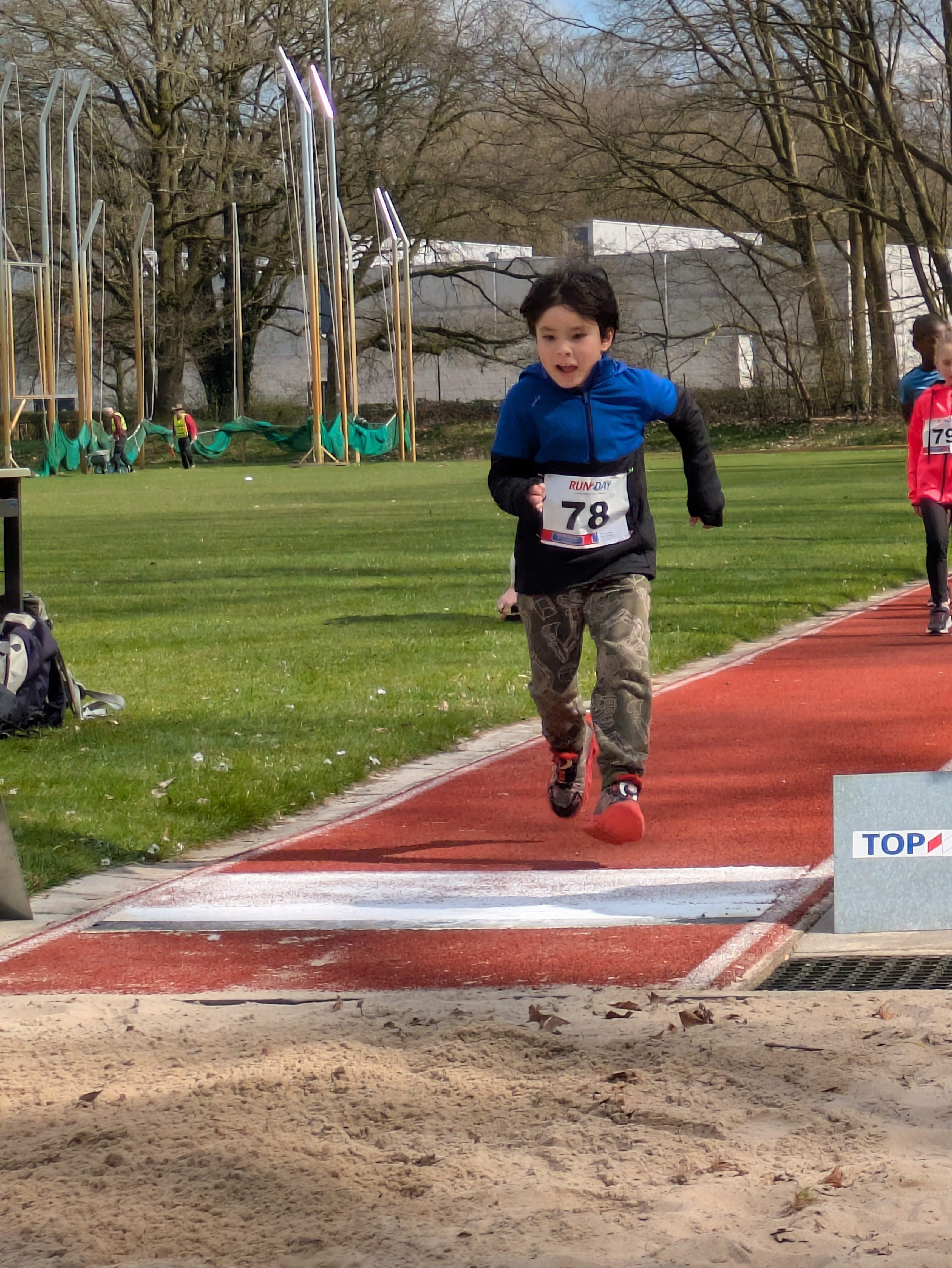 Tomas running determinedly in a race event, wearing number 78